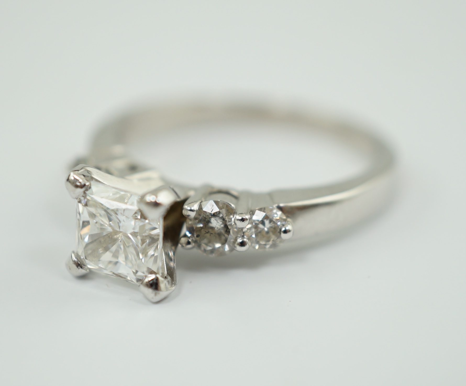 A modern 14k white gold and single stone diamond set ring, with four stone diamond set shoulders